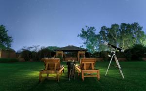 a man sitting in a lawn with two chairs and a camera at The Westin Sohna Resort & Spa in Gurgaon