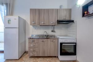 una cucina con frigorifero bianco e lavandino di Solebarocco del sud - trilocale a Vernole