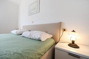 1 dormitorio con cama y mesita de noche con lámpara en Sabina More, en Preko