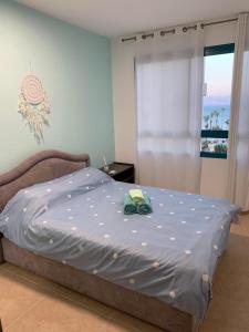 על שפת כנרת في طبرية: غرفة نوم مع سرير مع لحاف أزرق