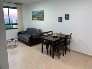 a living room with a table and chairs and a couch at על שפת כנרת in Tiberias