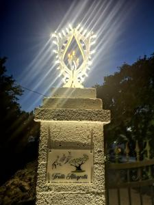 ein beleuchtetes Denkmal mit einem Schild vor der Sonne in der Unterkunft TRULLI ALLEGRETTI in Noci