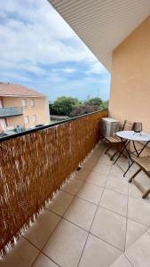 Un balcón con una valla de madera y una mesa en ADDIS 2 en Salon-de-Provence
