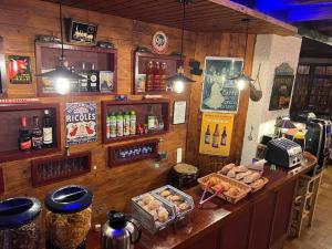 um bar com balcão com comida e bebidas em Aparthotel Le Petit Train em Luchon
