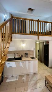 una cocina con armarios blancos y una escalera en ADDIS 2, en Salon-de-Provence
