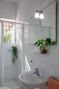a white bathroom with a sink and a mirror at CASA DE MECA, a 100m de la playa in Los Caños de Meca +15 photos