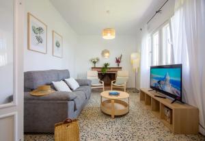 uma sala de estar com um sofá e uma televisão de ecrã plano em CASA DE MECA, a 100m de la playa em Los Caños de Meca