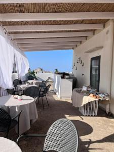 a restaurant with tables and chairs with a view of the ocean at Palazzo Angelelli in Gallipoli