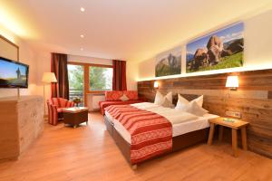 Habitación de hotel con cama y TV de pantalla plana. en Sporthotel Walliser en Hirschegg