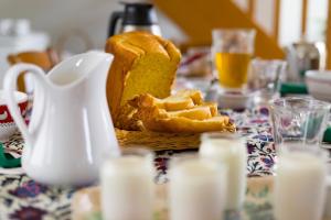 una mesa con un plato de pan y una jarra de leche en Jolie vache déguisée en fleurs, chambre d'hôte à Soulosse en Soulosse-sous-Saint-Élophe