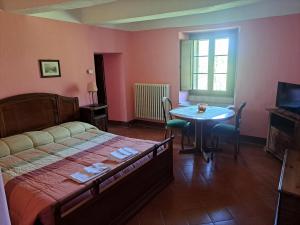 a bedroom with a bed and a table and a television at LA CEGNA in Montemaggio
