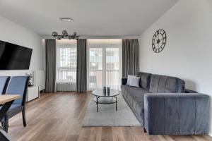 a living room with a couch and a table at Downtown Apartments Bastion Wałowa City Center & Parking in Gdańsk