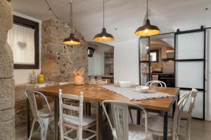 een keuken en eetkamer met een houten tafel en stoelen bij Flateli Corçà Townhouse in Corçà