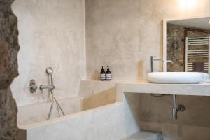 een badkamer met een wastafel en een bad bij Flateli Corçà Townhouse in Corçà