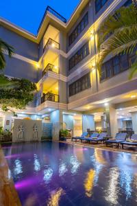 a hotel swimming pool in front of a building at Siem Reap Comforts Hostel in Siem Reap