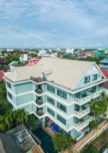 - une vue sur un bâtiment blanc avec des palmiers dans l'établissement Siem Reap Comforts Hostel, à Siem Reap