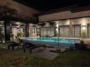 a house with a swimming pool at night at Ma PoolVilla Khanom in Khanom
