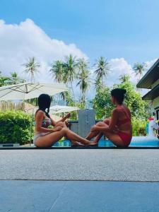 two women in bathing suits sitting next to each other at Ma PoolVilla Khanom in Khanom