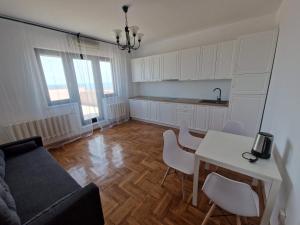 een woonkamer met een bank en een tafel en stoelen bij Leon Apartment in Constanţa