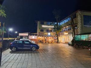 un coche azul estacionado en una calle por la noche en ONELLA REGENCY, en Panchgani