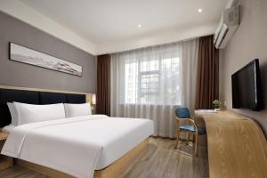 a hotel room with a large white bed and a desk at Morninginn, Tidu Middle Road in Lengshuijiang