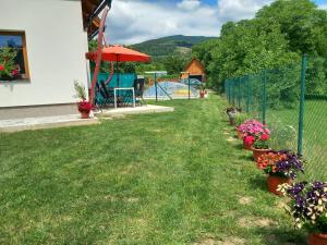een tuin met een hek en bloemen en een speeltuin bij apartmán pod Ještědem in Světlá pod Ještědem