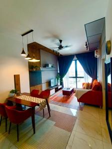 a living room with a table and red chairs at Zulanie Suite Troika Residence, SPACIOUS AND COZY WITH POOL, Free Wifi & Netflix in Golden Triangle of Kota Bharu in Kota Bharu