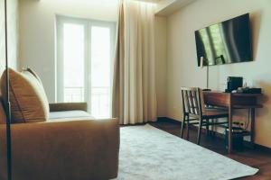 a living room with a couch and a desk at Estalagem Santa Iria Hotel & Spa in Tomar