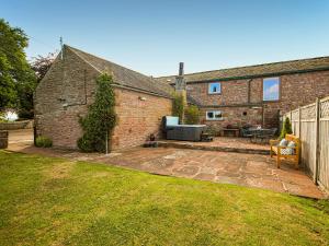a brick house with a patio in the yard at The Bothy in Ivegill