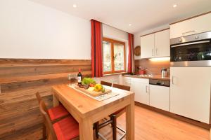cocina con mesa de madera y suelo de madera en Sporthotel Walliser en Hirschegg