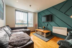 a living room with a green accent wall at Central Oasis, Serene Convenient 2-Bedroom Haven in L1 in Liverpool