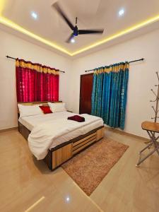 1 dormitorio con 1 cama grande y cortinas coloridas en Wayanad Days, en Mananthavady