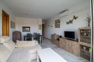 - un salon avec un canapé et une télévision dans l'établissement Lightbooking Ronda del Estero, à San Fernando