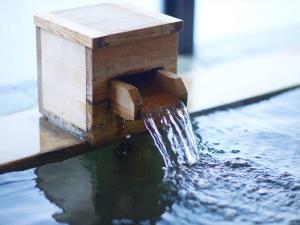 a bird house with a waterfall in the water at Kyoto Hot Spring Hatoya Zuihokaku Hotel in Kyoto