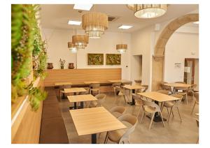 een leeg restaurant met houten tafels en stoelen bij Hotel Casa Palacio Pereros in Cáceres