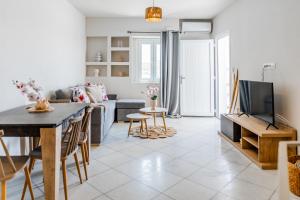 a living room with a couch and a table with a tv at Petradia Villas in Naxos Chora