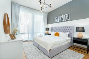 a bedroom with a bed and a large window at White Sage - Amna Tower in Dubai
