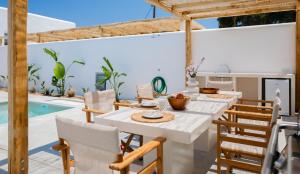 a dining room with a table and chairs and a swimming pool at Petradia Villas in Naxos Chora