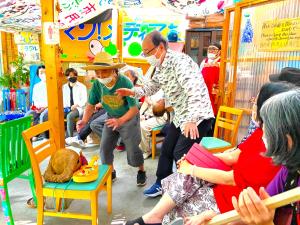 een man met een hoed in een kamer met mensen bij Kamagasaki University of the Arts Cafe Garden Guest House aka Cocoroom in Osaka