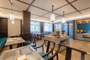 長沙市にあるTill Bright Hotel, Changsha Yanghu University of Traditional Chinese Medicineのテーブルと椅子のあるレストラン、バー