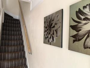 eine Treppe mit zwei Gemälden an der Wand und einer Treppe in der Unterkunft SILVERDALE HOUSE in Southend-on-Sea