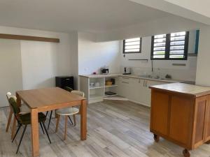 eine Küche mit einem Tisch und Stühlen im Zimmer in der Unterkunft Chez Romuas in Le Tampon