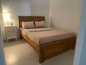 ein Schlafzimmer mit einem Holzbett und einem Nachttisch in der Unterkunft Chez Romuas in Le Tampon