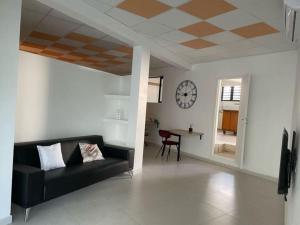 ein Wohnzimmer mit einem schwarzen Sofa und einem Tisch in der Unterkunft Chez Romuas in Le Tampon