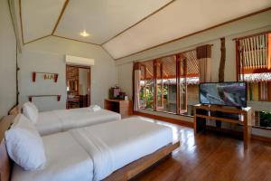 a bedroom with two beds and a flat screen tv at Peter Pan Resort @ Koh Kood in Ko Kood