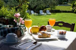 a table with food and glasses of orange juice at Carlo's Hotel in Castagneto Carducci
