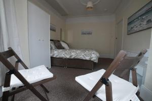 a bedroom with two chairs and a bed in it at SILVERDALE HOUSE in Southend-on-Sea