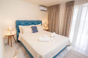 Un dormitorio con una cama azul con toallas. en Sweet Home Houses 1, en Kalamata