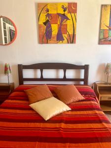 een slaapkamer met een bed met een rode en oranje deken bij Studio Rio Marina sul mare AC in Rio Marina