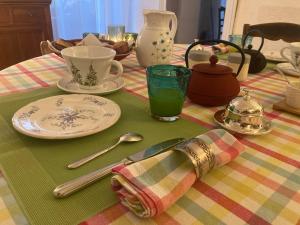 una mesa con un mantel con platos y utensilios en Chambre d'Hôtes LES ROCHES, en Corme-Royal